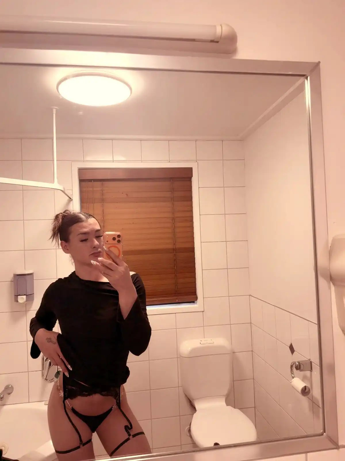 London taking a mirror selfie in a black top